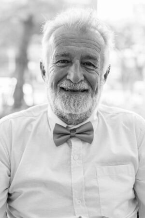 Handsome bearded senior tourist man exploring the city in black and whiteの写真素材