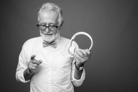 Handsome bearded senior man wearing stylish clothes in black and whiteの写真素材