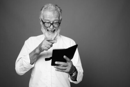 Handsome bearded senior man wearing stylish clothes in black and whiteの写真素材