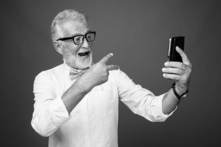 Handsome bearded senior man wearing stylish clothes in black and whiteの写真素材