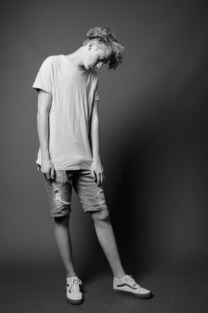 Skinny young man with curly hair in black and whiteの写真素材
