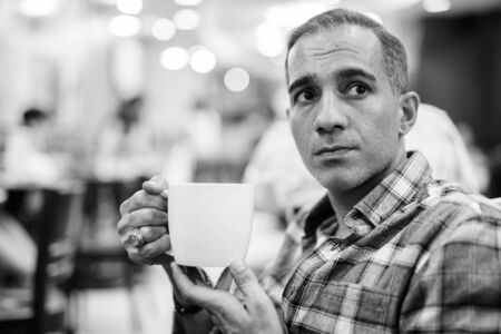 Mature Persian man relaxing inside the coffee shopの写真素材