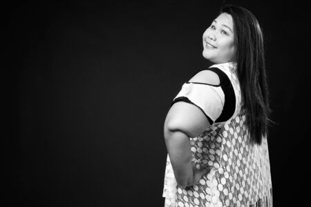 Beautiful overweight Asian woman against black backgroundの写真素材