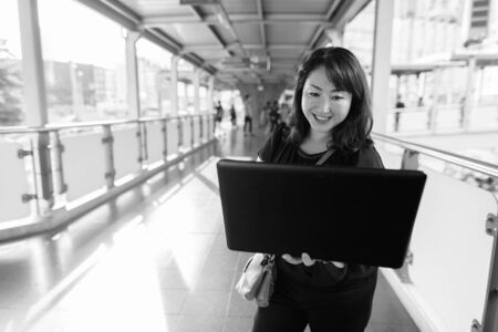 Mature beautiful Asian woman exploring around the cityの写真素材