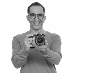 Mature happy Persian man taking picture with cameraの写真素材