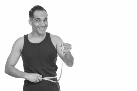 Mature happy Persian man checking measurements getting ready for gymの写真素材