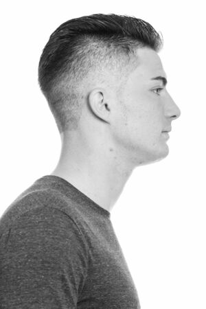 Studio shot of young handsome man isolated against white background in black and whiteの写真素材