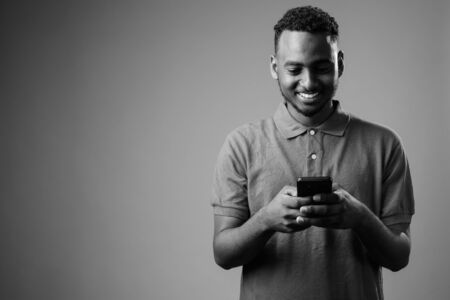 Young handsome African man against gray backgroundの写真素材