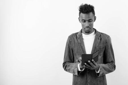Young bearded African man wearing denim jacket against white backgroundの写真素材