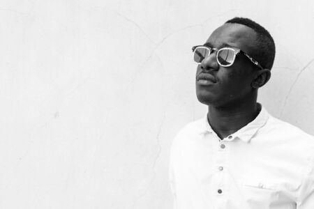 Young handsome African man against concrete wall outdoors