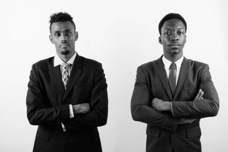Two young African businessmen against white backgroundの写真素材