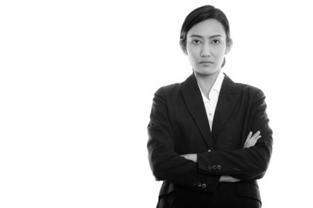 Studio shot of young Asian businesswoman with arms crossedの写真素材