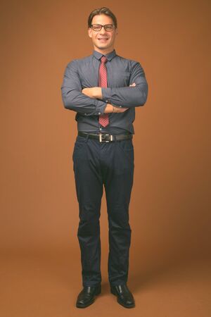 Studio shot of businessman against brown backgroundの写真素材