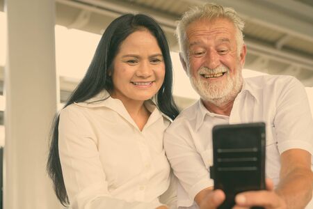 Mature multi-ethnic couple happy and in love while exploring the city of Bangkok, Thailand