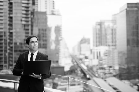 Handsome Persian businessman against view of the cityの写真素材