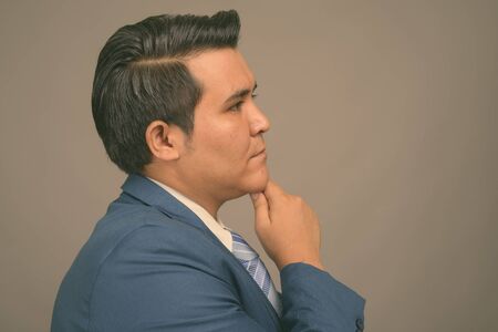 Young multi ethnic businessman in suit against gray backgroundの写真素材