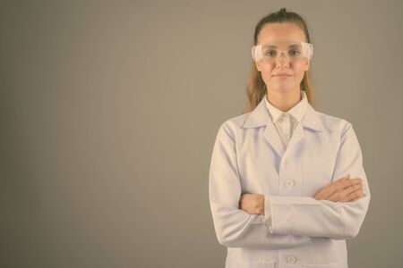 Young beautiful woman doctor against gray backgroundの写真素材