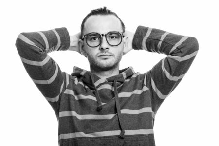 Studio shot of young man brushing hair back with both hands