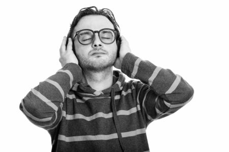 Studio shot of young man listening to music with eyes closedの写真素材