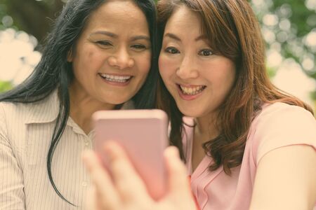 Two mature Asian women together outside the mall in Bangkok city