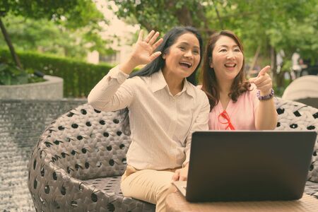 Two mature Asian women together outside the mall in Bangkok cityの写真素材