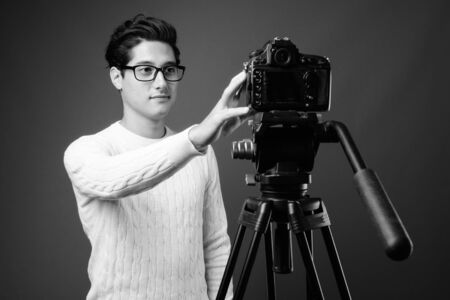 Portrait of young handsome man against gray background