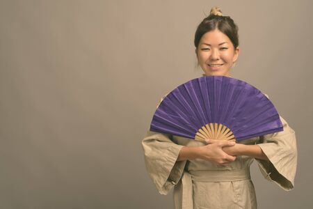 Young beautiful Kazakh woman against gray backgroundの写真素材