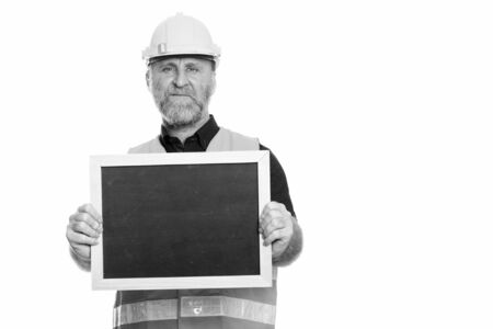 Mature bearded man construction worker showing blackboardの写真素材