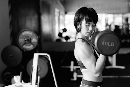 Young beautiful Asian woman working out at the gymの写真素材