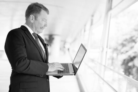 Handsome senior businessman with mustache exploring the cityの写真素材