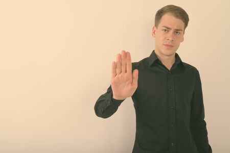 Portrait of young handsome businessman against white background