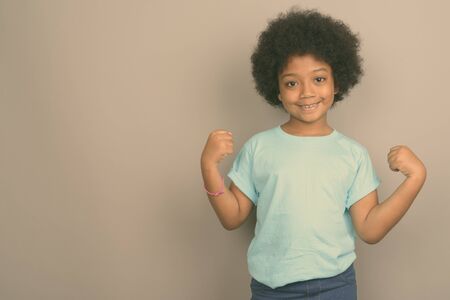 Young cute African girl against gray backgroundの写真素材