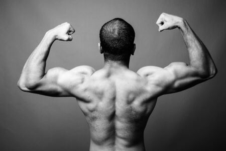 Muscular Indian man with mustache shirtless against gray backgroundの写真素材