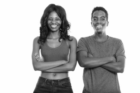 Studio shot of happy black African sister and brother smiling with arms crossedの写真素材