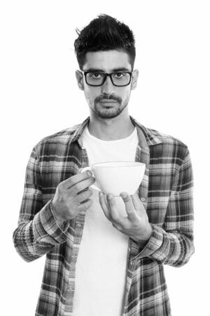 Studio shot of young Persian man holding coffee cupの写真素材