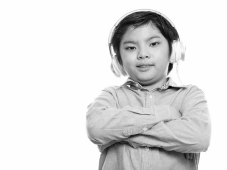 Happy Japanese boy smiling while listening to music with arms crossed