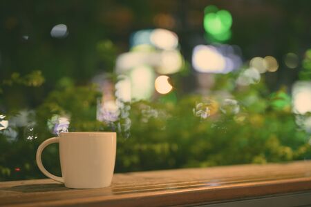 Coffee Cup On Wooden Table In Restaurant At Night