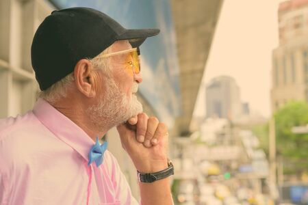 Portrait of handsome senior tourist man wearing stylish clothes while exploring the city of Bangkok