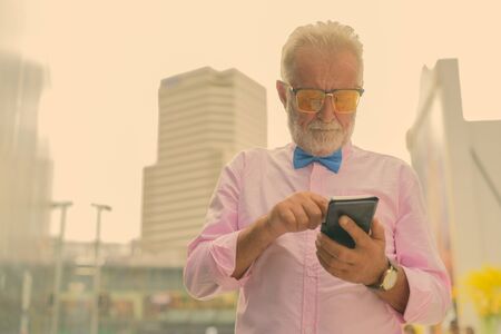 Portrait of handsome senior tourist man wearing stylish clothes while exploring the city of Bangkok