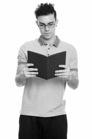 Studio shot of young man reading bookの写真素材