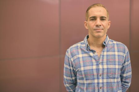 Mature Persian hipster man against glossy wallの写真素材