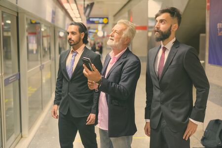 Three multi ethnic bearded businessmen together around the city