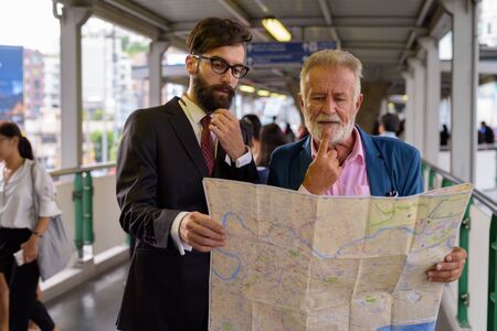 Two multi ethnic bearded businessmen together around the cityの写真素材