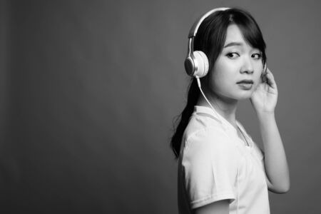Young beautiful Asian woman listening to music