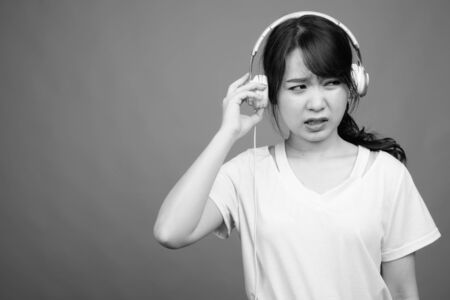Young beautiful Asian woman listening to musicの写真素材