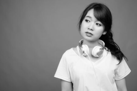 Portrait of young beautiful Asian woman wearing headphonesの写真素材