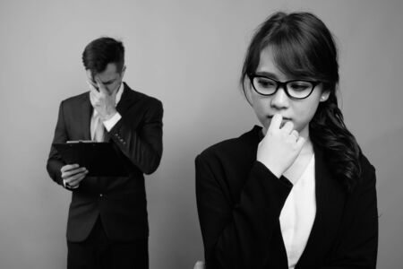 Young multi ethnic business couple working together against gray backgroundの写真素材