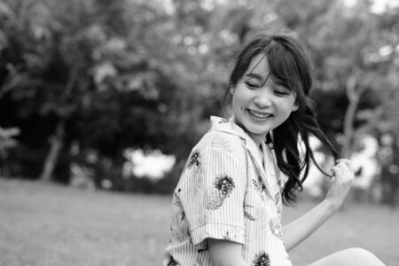 Young beautiful Asian tourist woman relaxing at the park