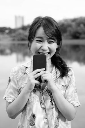 Young beautiful Asian tourist woman relaxing at the parkの写真素材