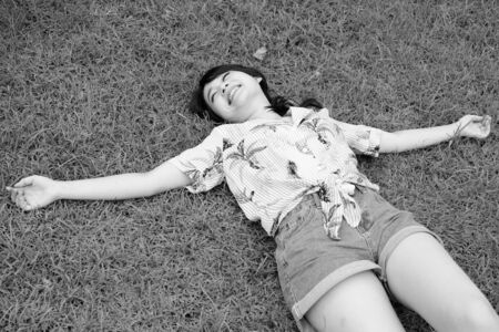 Young beautiful Asian tourist woman relaxing at the parkの写真素材